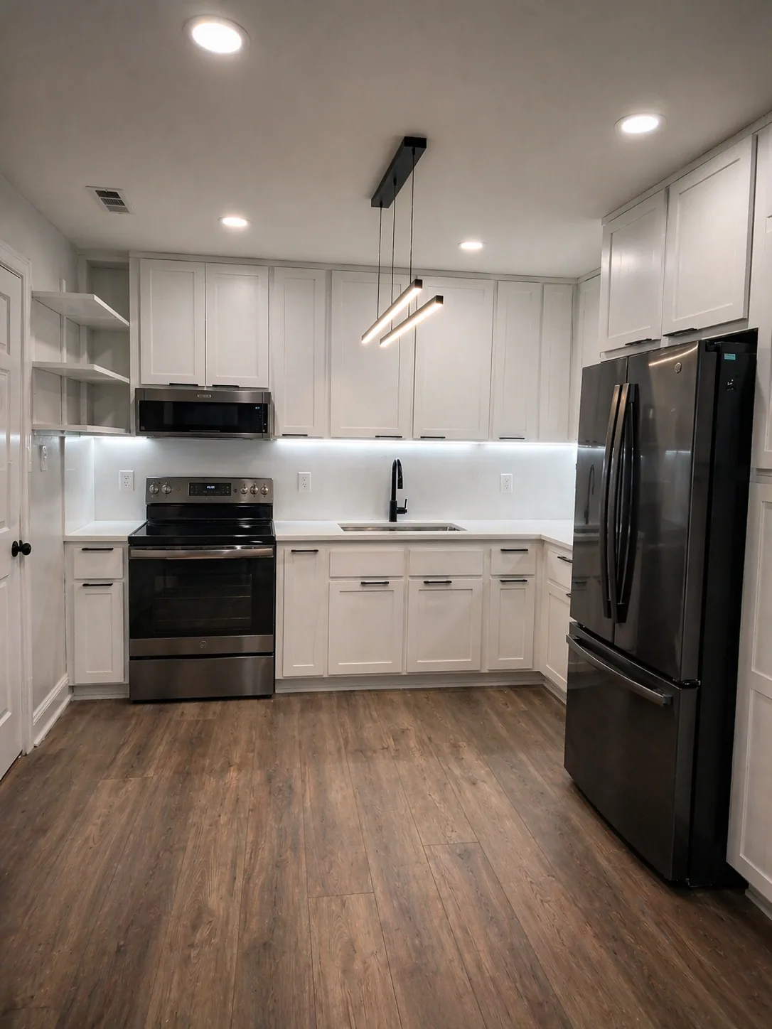 Modern kitchen remodel with white shaker cabinets, black stainless appliances, and wood-look flooring in Northern Virginia