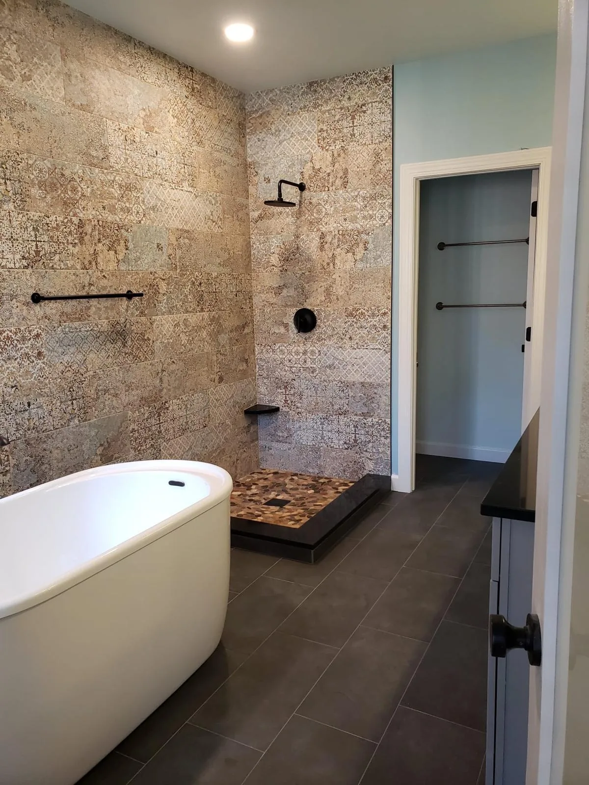 Open walk-in shower with decorative stone tile, Richmond VA bathroom remodel